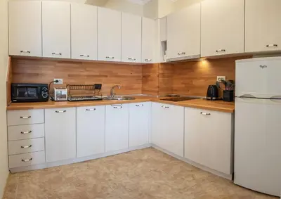 a kitchen with white cabinets and a white refrigerator at Melia lux apartment in Ravda