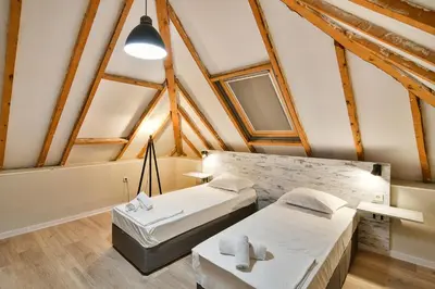 two beds in a room with wooden beams at Central Flats with parking in Varna City