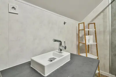 a bathroom with a white sink in a room at Central Flats with parking in Varna City