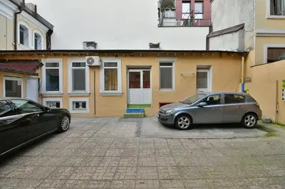 two cars parked in a parking lot in front of a building at Central Flats with parking in Varna City