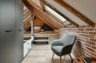 a room with a chair and a brick wall at Central Flats with parking in Varna City