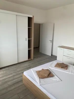 a bedroom with a white bed with two towels on it at Апартамент Енигма/Apart Enigma in Sveti Vlas