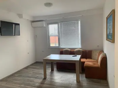 a living room with a couch and a table at Апартамент Енигма/Apart Enigma in Sveti Vlas