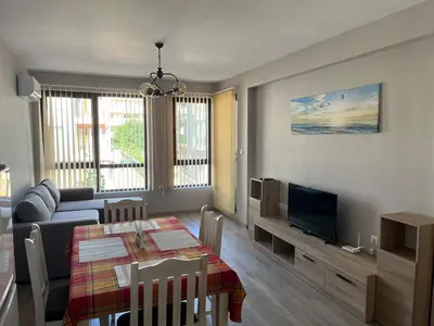 a living room with a table and a couch and a television at Apartment Mihaela - 2 in Burgas City