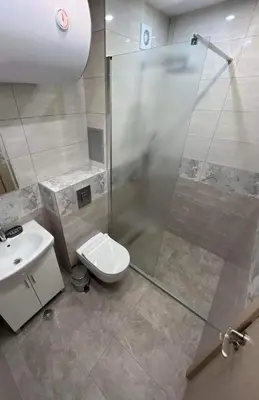 a bathroom with a shower and a toilet and a sink at Apartment Mihaela - 2 in Burgas City