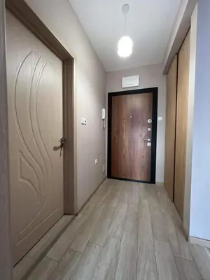 an empty hallway with a door and a room with wooden floors at Apartment Mihaela - 2 in Burgas City