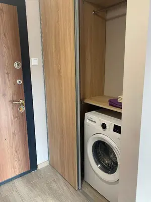 a laundry room with a washing machine and a door at Apartment Mihaela - 2 in Burgas City