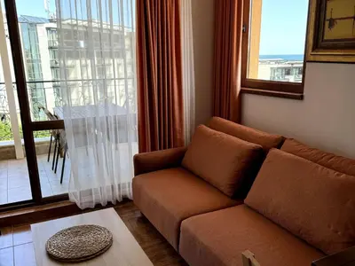 a living room with a couch and a large window at Apartment Royal Bay Sveti Vlas in Sveti Vlas