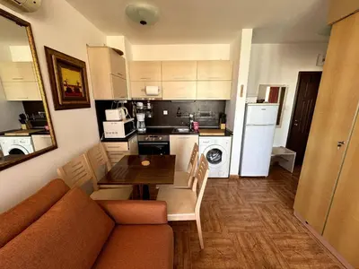 a living room with a table and a kitchen at Apartment Royal Bay Sveti Vlas in Sveti Vlas
