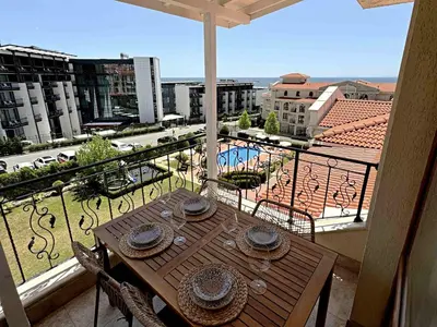 a table on a balcony with a view of a city at Apartment Royal Bay Sveti Vlas in Sveti Vlas