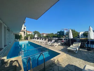 a swimming pool with chairs and umbrellas on a building at FREGATA 2 Studio Sveti Vlas in Sveti Vlas