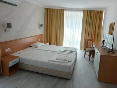 a bedroom with a bed and a desk and a television at Sol e Mar in Sunny Beach
