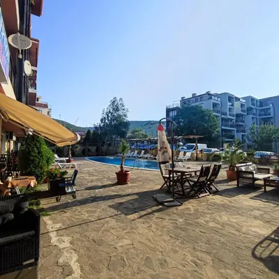 a patio with a table and chairs and a pool at Panorama Bay 2 - Apartments by the beach in Sveti Vlas