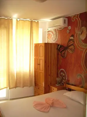 a bedroom with a bed with butterflies on the wall at Hotel Pasians in Pomorie
