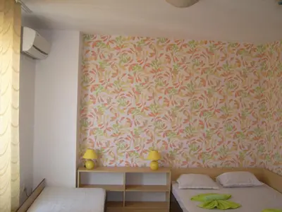 a bedroom with two beds and a pink wall at Hotel Pasians in Pomorie