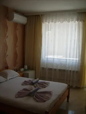 a bedroom with a bed with two towels on it at Hotel Pasians in Pomorie