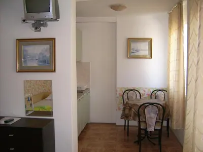 a small room with a table and a television at Hotel Pasians in Pomorie