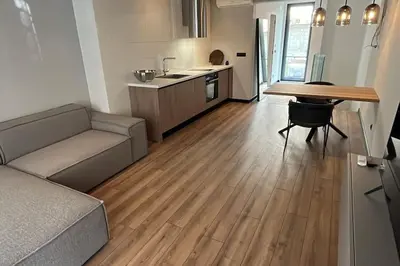 a living room with a couch and a table and a kitchen at Amber Home - brand NEW luxury 1 bedroom apartment located in the very city center in Varna City
