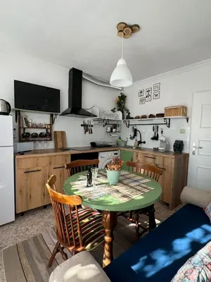 a kitchen with a table and chairs and a kitchen with a refrigerator at The Master and Margarita Apartment, Майстора и Маргарита 2 in Burgas City