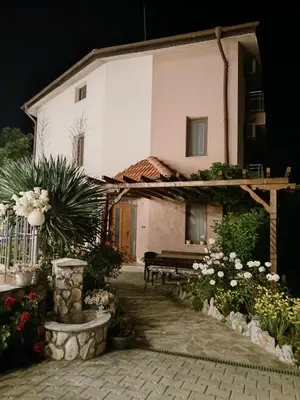 a house with a bench and flowers in front of it at Zenith Guest House in Sozopol