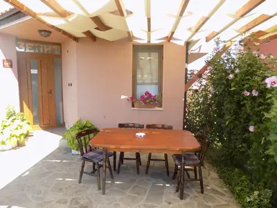 a wooden table and chairs on a patio at Zenith Guest House in Sozopol
