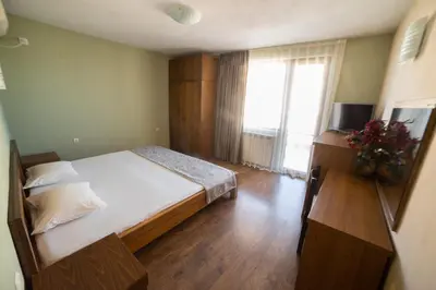a bedroom with a bed and a large window at Zenith Guest House in Sozopol