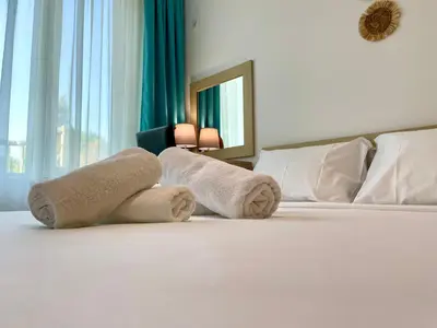 a hotel room with a bed with towels on it at Budget First Sea Line Apt. FLORA in Pomorie
