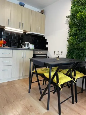 a black table with yellow chairs in a kitchen at Budget First Sea Line Apt. FLORA in Pomorie