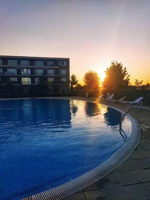 a large swimming pool with chairs in front of a building at Lovely bright studio on Sunny Beach in Sunny Beach