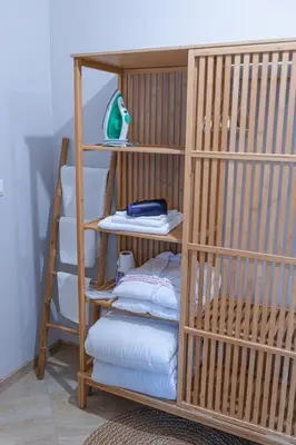 a wooden bunk bed with a stack of pillows at Дизайнерско Студио в Модерна сграда -Молимаркс Делукс Студио Бургас in Burgas City