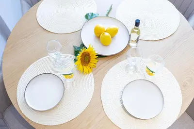 a table with white hats and a bottle of wine at Дизайнерско Студио в Модерна сграда -Молимаркс Делукс Студио Бургас in Burgas City