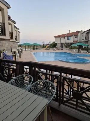 a swimming pool with two chairs and a table at Dream Villa in Imperial Heights Villas in Sunny Beach