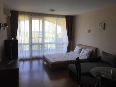a room with a bed and a couch and a window at Apartments Atia Resort in Chernomorets