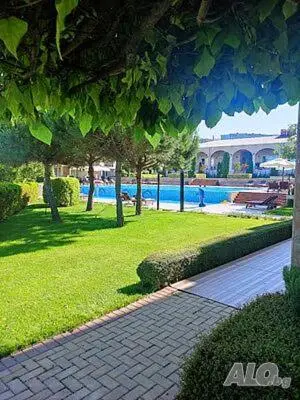 a brick walkway next to a swimming pool with a resort at Apartments Atia Resort in Chernomorets