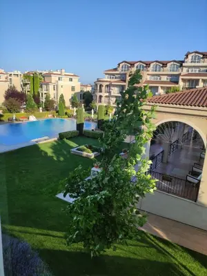 a tree in the yard of a building at Apartments Atia Resort in Chernomorets