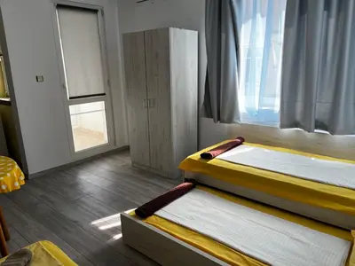 two beds sitting in a room with a window at Romance in Pomorie