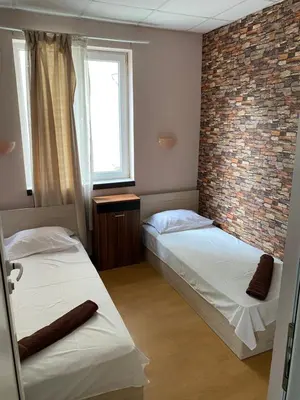 two beds in a room with a brick wall at Romance in Pomorie