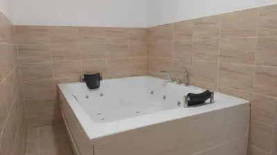a bathroom with a bath tub with two black heels at COCO Coworking & Coliving in Aheloy