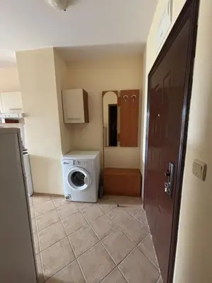 a bathroom with a washing machine in a room at Galeria Holiday Apartments in Obzor