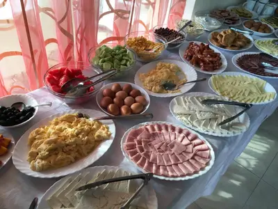 a table filled with different types of food on plates at Beatris Family House in Sunny Beach
