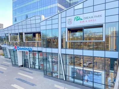 a glass building with a sign on the side of it at Arena MALL Galleria View and Securities Parking1 in Burgas City