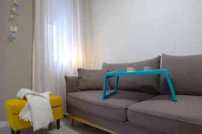 a living room with a couch with a table on it at Апартамент МАРГО in Burgas City