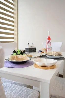 a white table with plates of food on it at Sunset Luxury Apartment in Varna City
