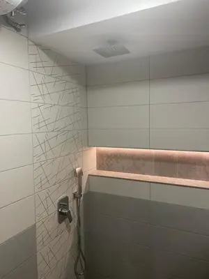 a bathroom with a shower with a toilet and a light at Sunset Luxury Apartment in Varna City