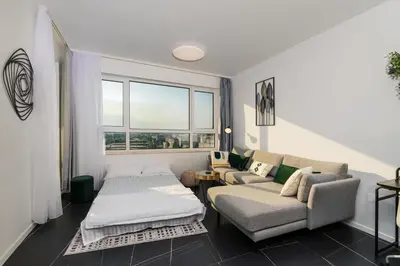 a living room with a couch and a bed at Arena MALL Galleria View and Securities Parking2 in Burgas City