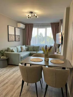 a living room with a couch and a table and chairs at Villi’s Home in Burgas City