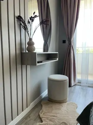 a living room with a stool and a window at Villi’s Home in Burgas City
