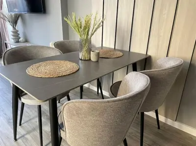 a black table with chairs and a vase of flowers on it at Villi’s Home in Burgas City