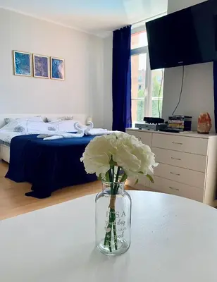 a vase with flowers on a table in a bedroom at Apartament Esperanza in Sunny Beach