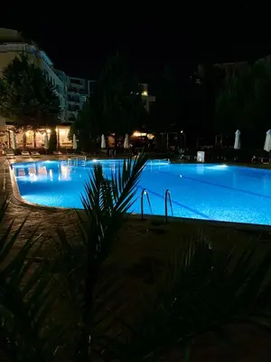 a large swimming pool lit up at night at Apartament Esperanza in Sunny Beach